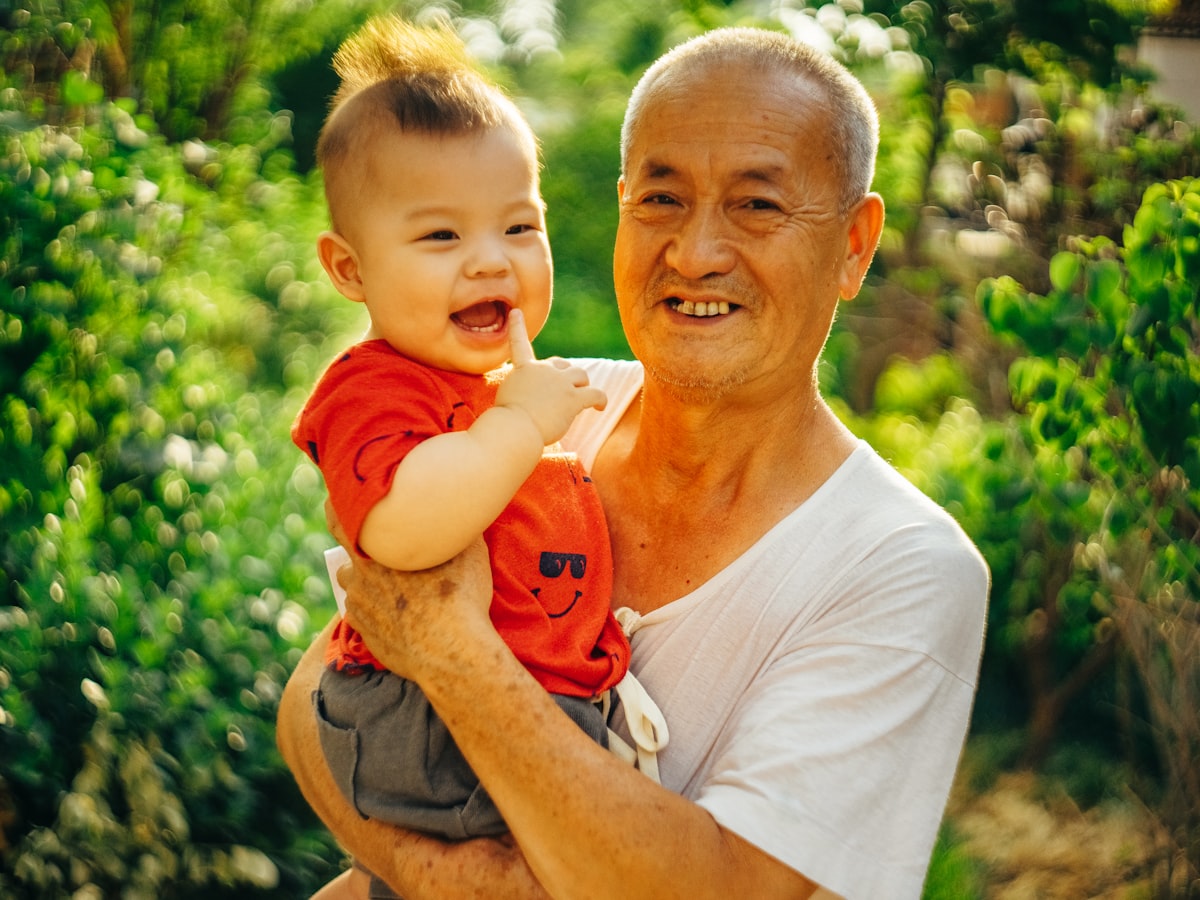 Ông vui vẻ bế cháu — ba thế hệ một nhà